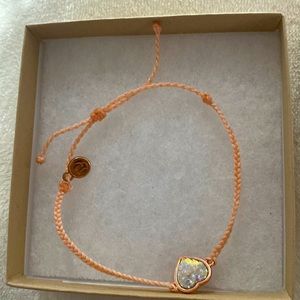 The bracket is a peachy color , and the heart has a mirmaid type of print